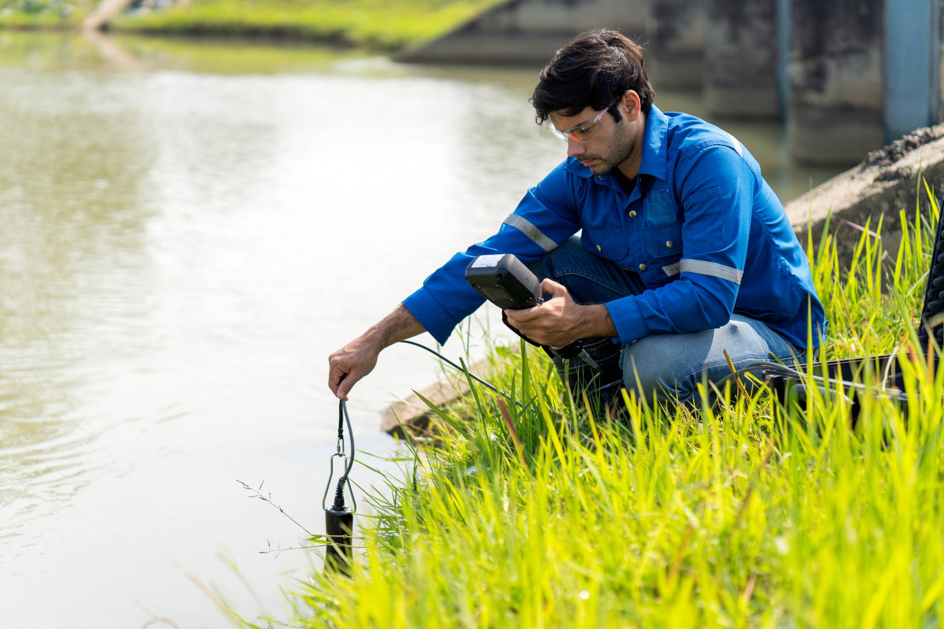 A technician use the Professional Water Testing equipment to measure the water quality at the public canal ,Portable multi parameter water quality measurement ,water quality monitoring concept