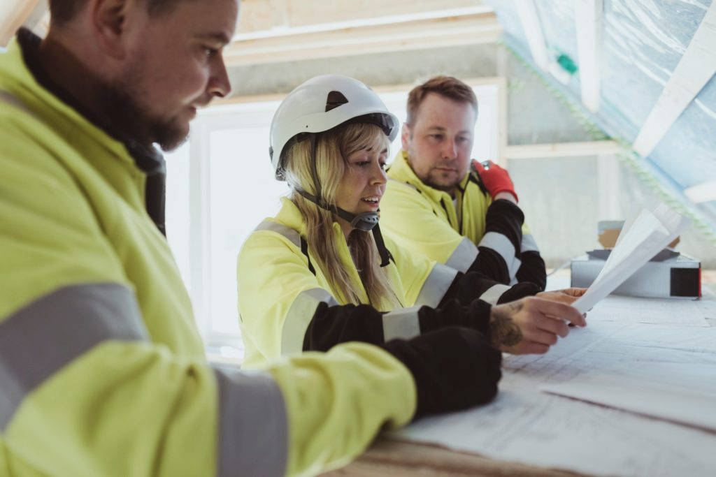 Site Management Safety Training Scheme Refresher, 3 trainees reviewing paperworks on site