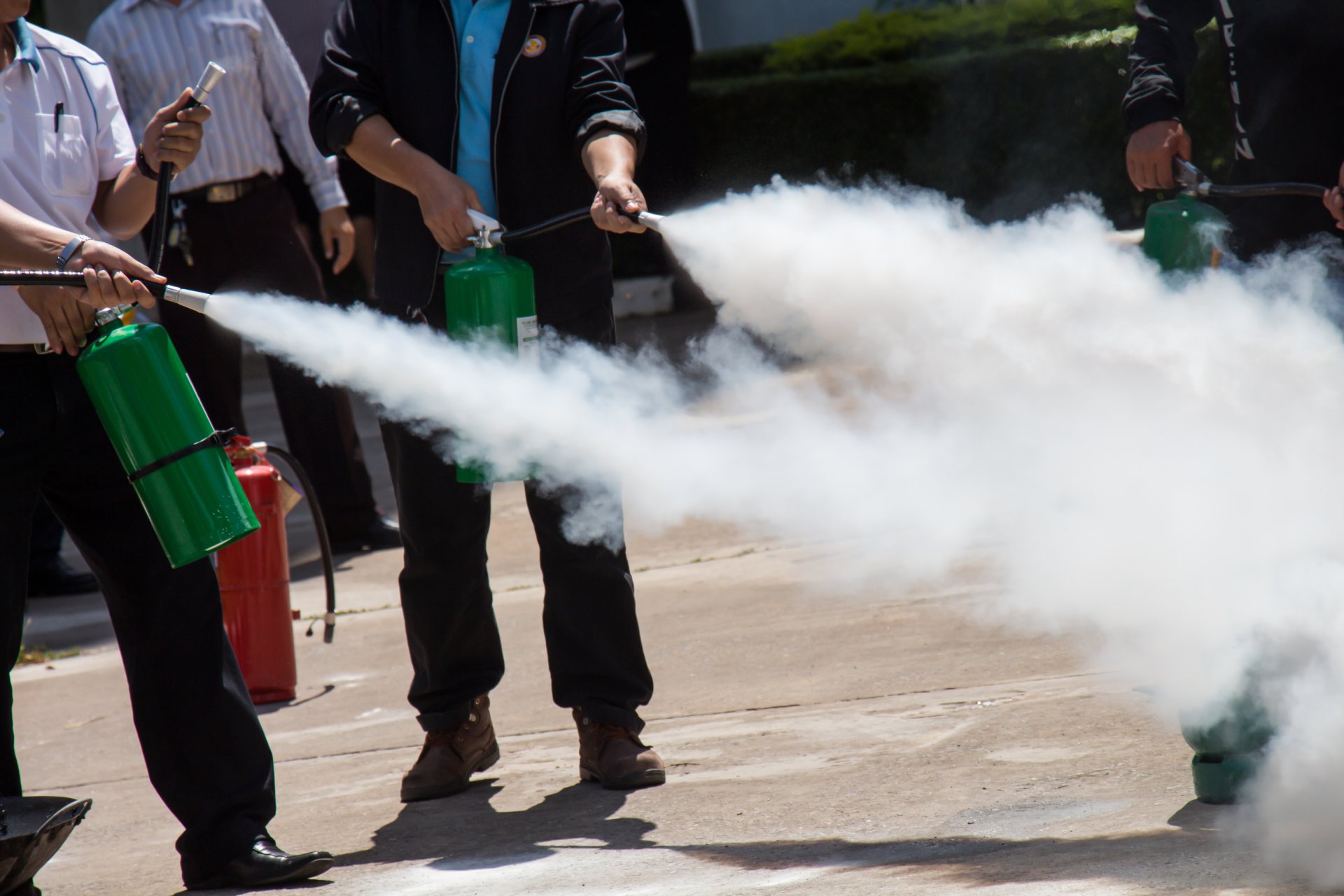 Instructor showing how to use a fire extinguisher on a training fire